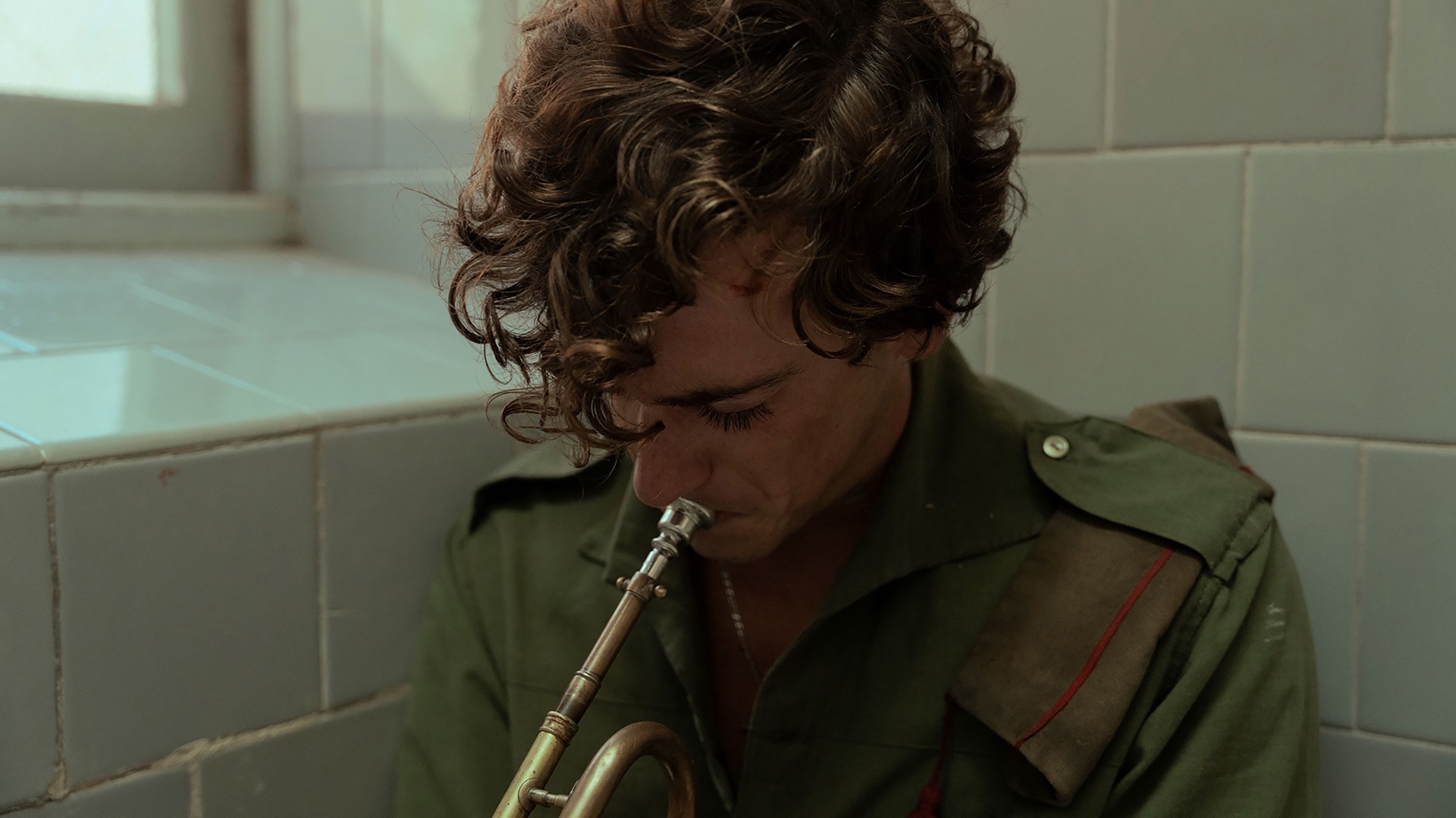 Sebastián, interpretado por Guitarricadelafuente, toca um instrumento enquanto veste um uniforme militar.